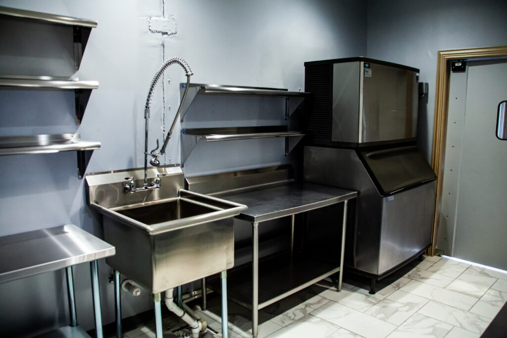 Prep Kitchen Equipped With Ice Machines, Commercial Grade Large Stainless Steel Refrigerators, Stainless Steel Shelves & Tables, Commercial Grade Dishwashing Sink With Extendable Spray Nozzle for easy Cleaning, Tile Floors with inlaid Drainage System.