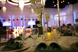 Recepción nupcial, lugar para celebrar la boda, bar completo, comodidades, novios, combinación de colores verde y dorado, centros de mesa altos, flores blancas y crema