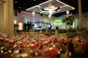 Recepción nupcial, lugar para celebrar la boda, bar completo, comodidades, novios, combinación de colores verde y dorado, centros de mesa altos, flores blancas y crema