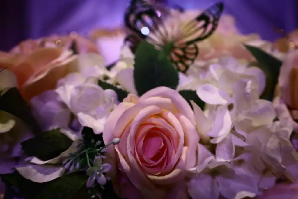 Honoree table at a Quinceañera party in a majestic banquet hall, featuring elegant decorations, floral centerpieces, and luxurious table settings